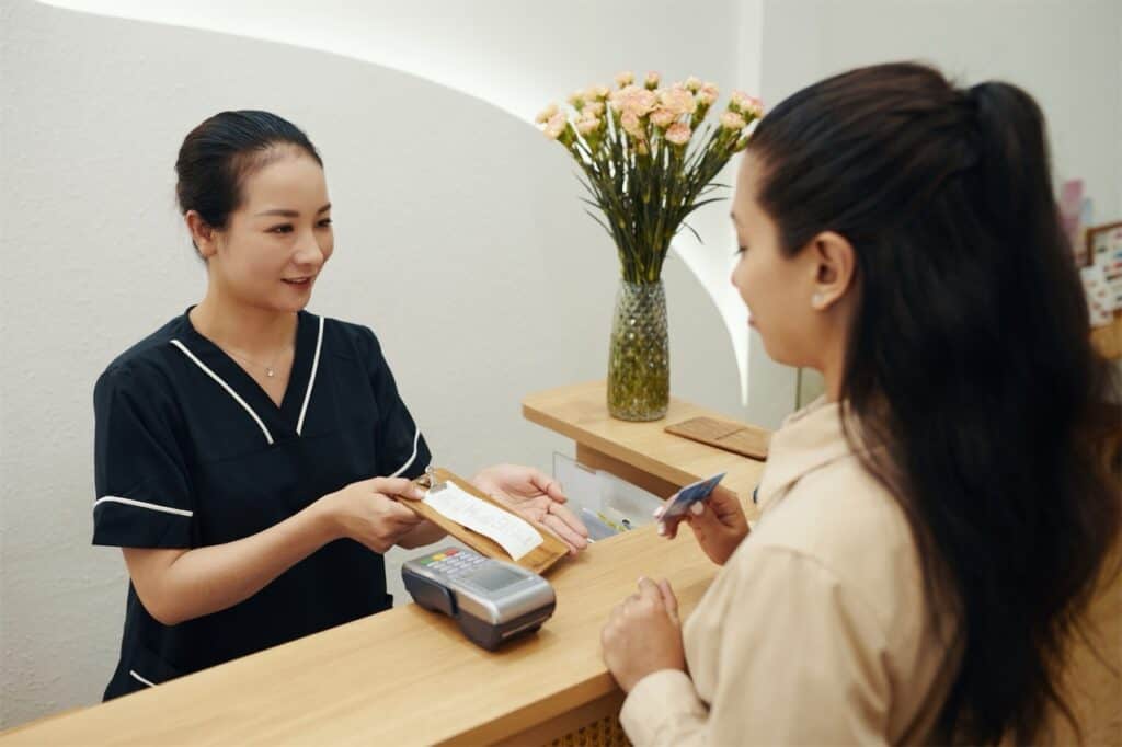Receptionist At Aesthetic Clinic Receiving Payment