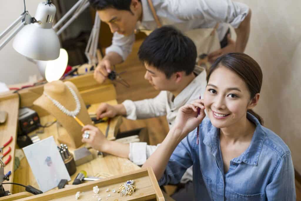 Asian jewelers working in studio