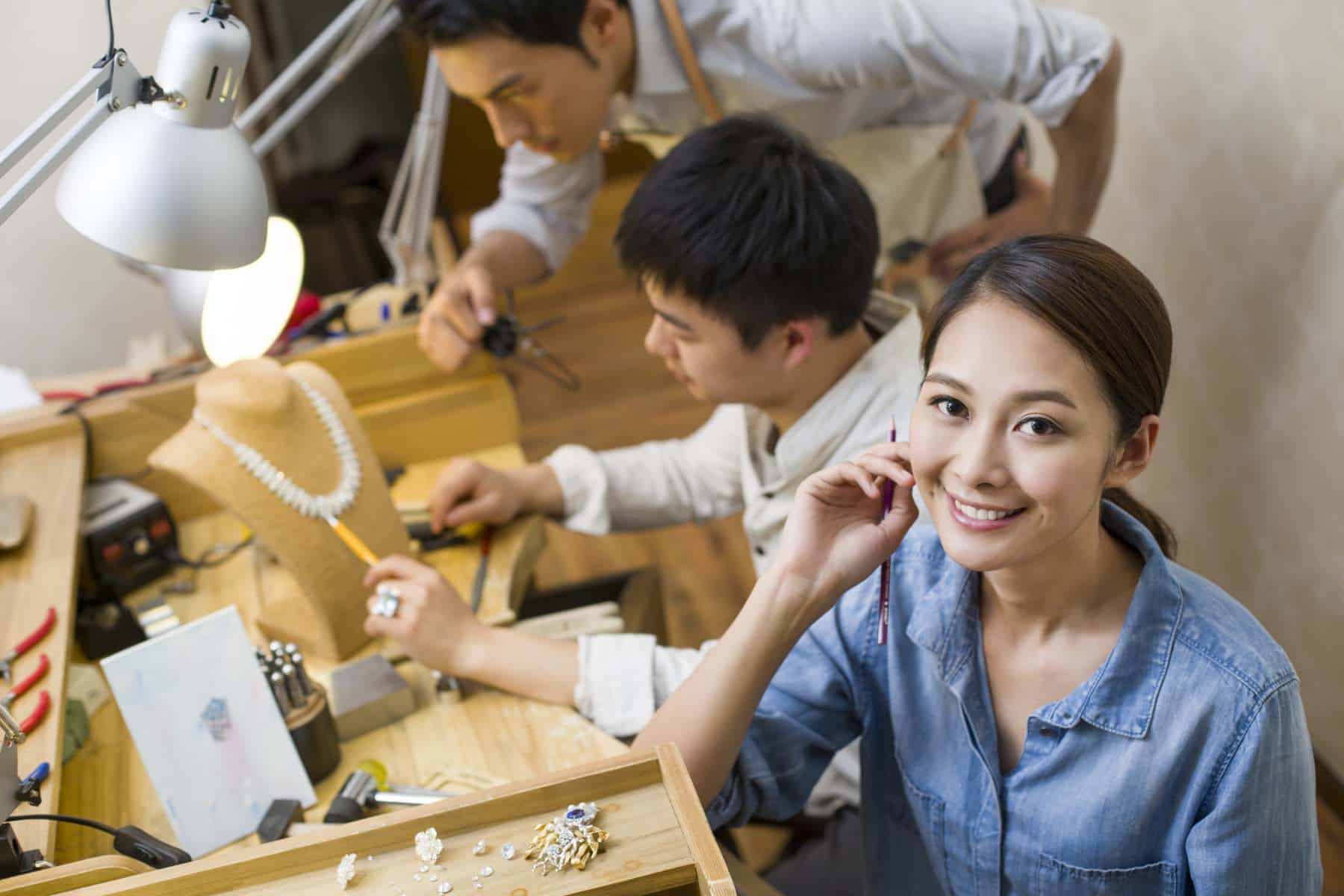 Asian jewelers working in studio